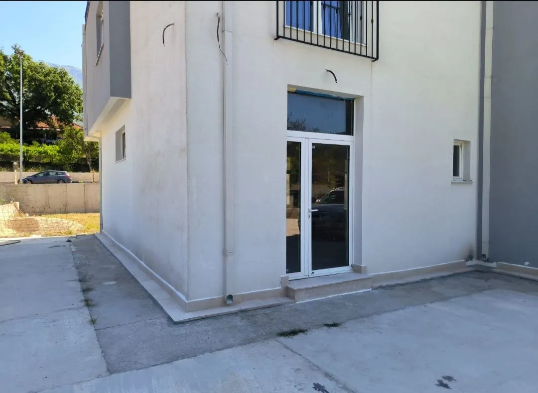 Exterior of a modern two-story house with an entrance door and paved yard.