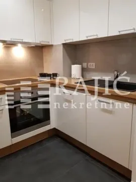 Modern kitchen with white cabinets and built-in appliances. - image 7