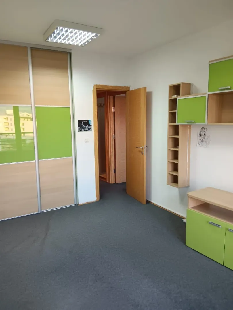 Furnished bedroom with green accents, a wardrobe, and an open door.