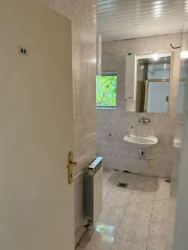 A bathroom with a sink and mirror seen through an open door. - image 14