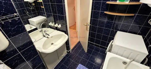 Kupatilo sa plavim pločicama, umivaonikom i veš mašinom. - image 9