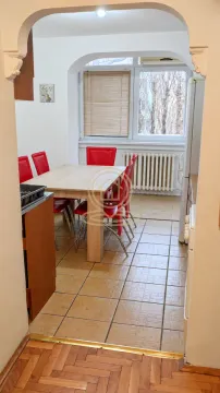 Kuhinja sa trpezarijom i crvenim stolicama, gledana kroz luk. - image 7