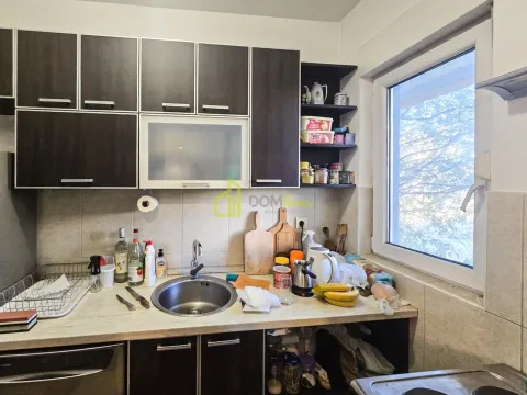 Kitchen with dark cabinetry, sink, and a window. - image 6