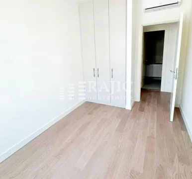 Empty bedroom with a built-in wardrobe and wooden flooring. - image 10