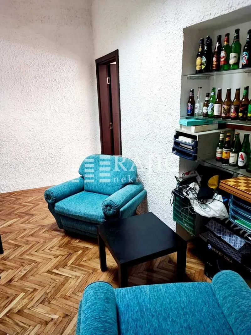 Living room with seating furniture and shelves with drinks.