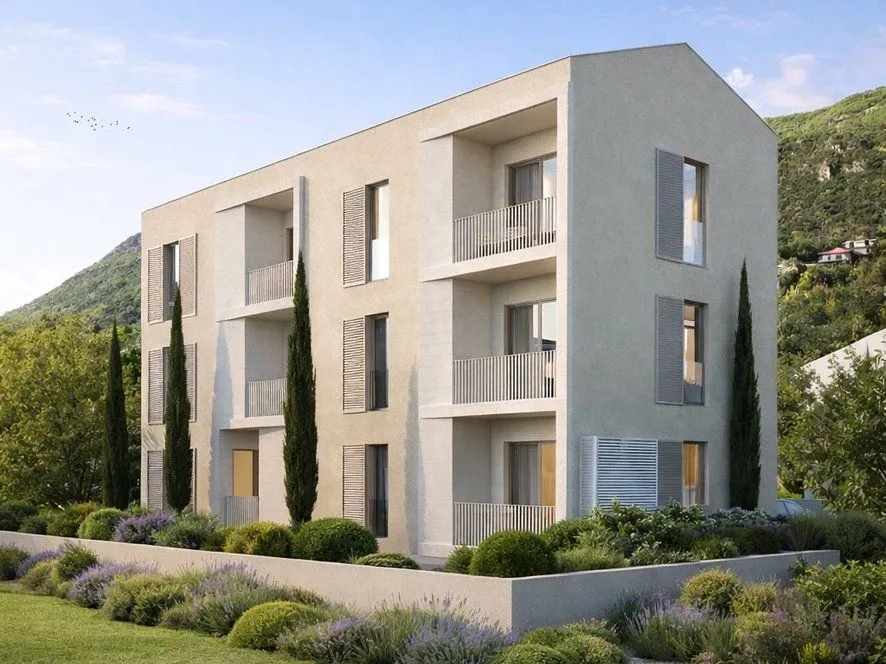 Eksterijer moderne stambene zgrade sa uređenim dvorištem i balkonskim terasama.