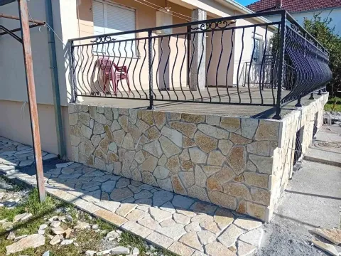 A terrace featuring decorative stone cladding and a metal railing. - image 20