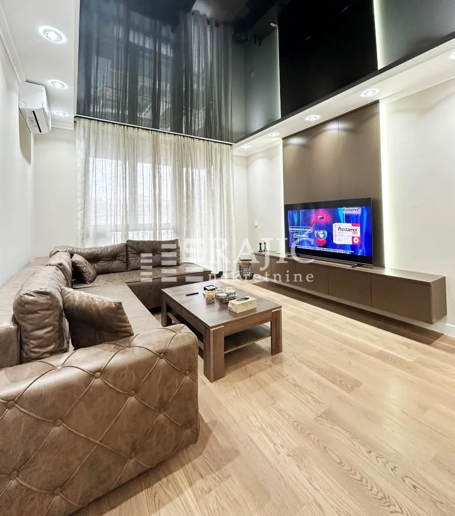 Modern and tidy living room with a sectional sofa and television.