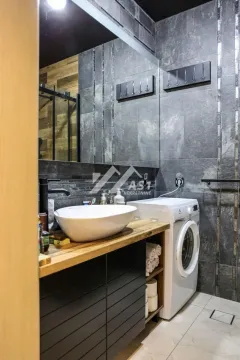 Moderno kupatilo sa umivaonikom na drvenom pultu i veš mašinom. - image 9