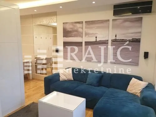 Living room with a blue sectional sofa and a white coffee table.