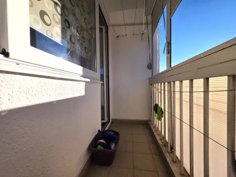 Manji zatvoreni balkon sa ogradom i korpom za veš na podu. - image 13