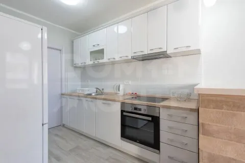 Bright and tidy kitchen with white cabinetry and built-in appliances. - image 9
