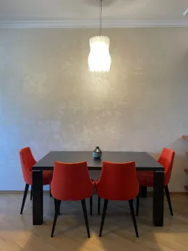 Trpezarijski sto sa narandžastim stolicama i visećom lampom. - image 3