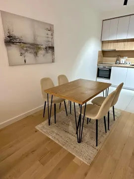 Dining area with a wooden table and chairs, connected to the kitchen. - image 4
