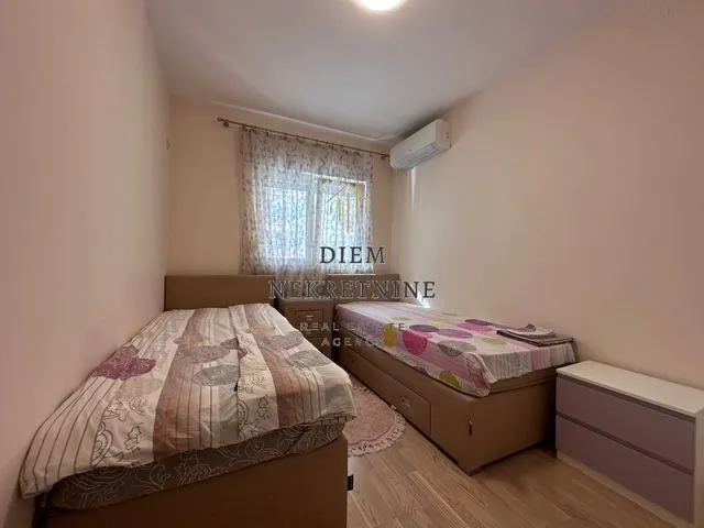 Smaller bedroom with two single beds and air conditioning.