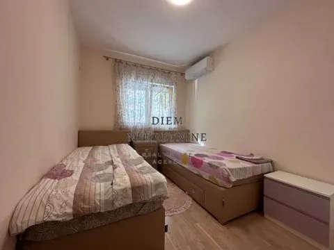Smaller bedroom with two single beds and air conditioning. - image 8