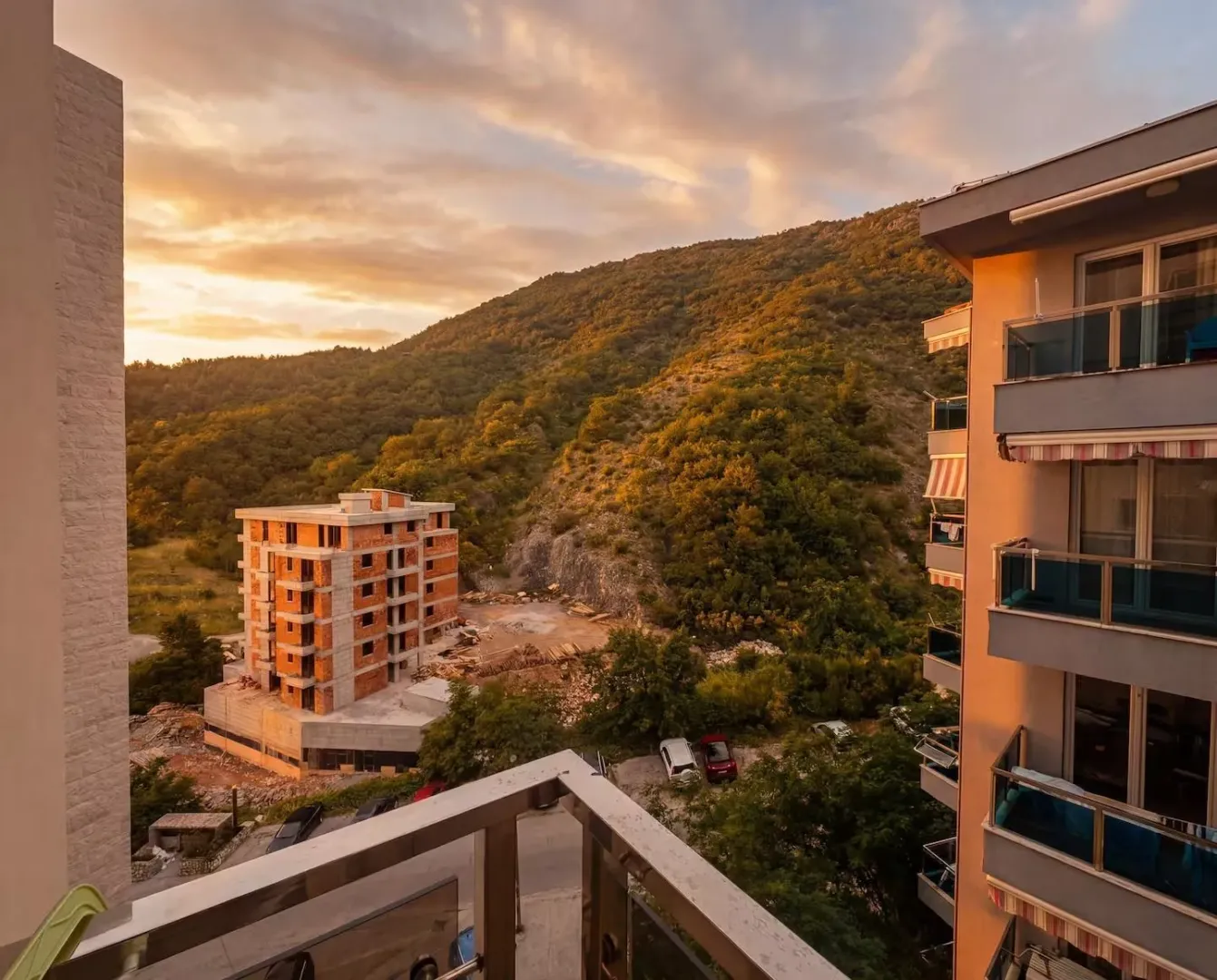 View from the terrace towards the mountain and surrounding buildings during sunset.