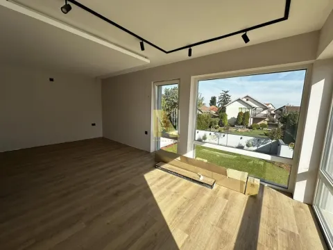 Empty room with wooden flooring and large windows overlooking the yard. - image 6