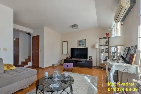 Living room with a sofa, television and hardwood flooring. - image 18