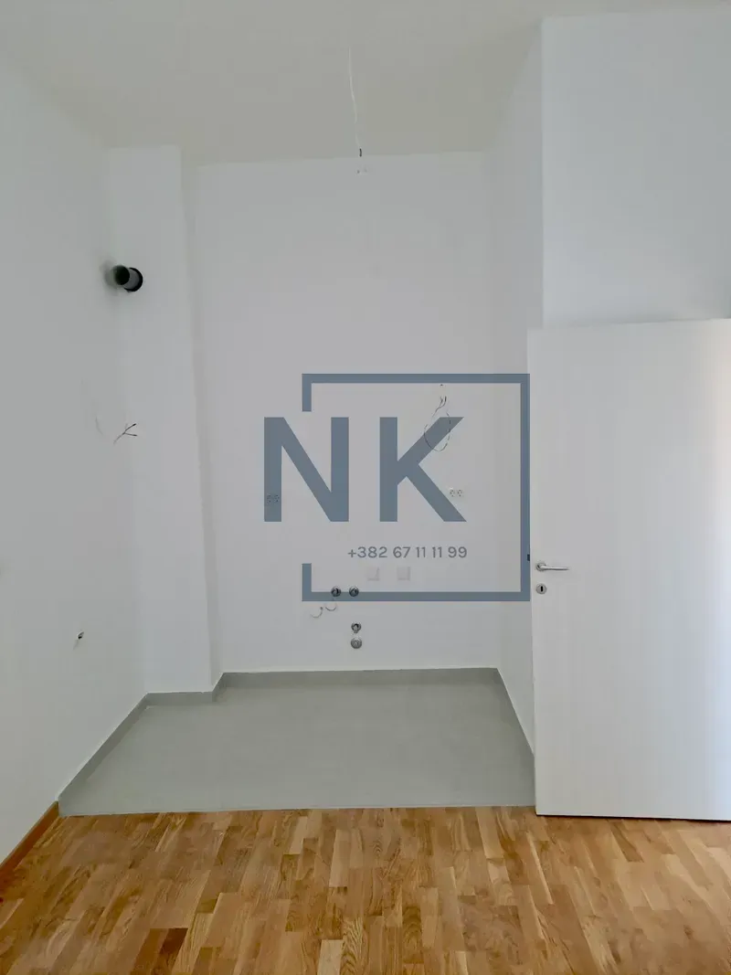 Empty room with white walls and a wooden floor.