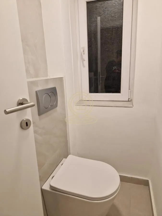 Manje kupatilo sa konzolnom šoljom i prozorom.