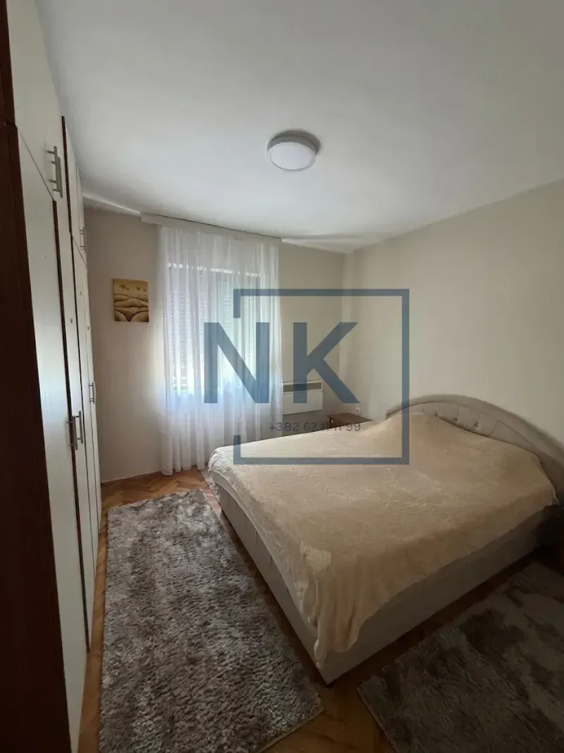 Bedroom with a double bed, large wardrobe, and window.