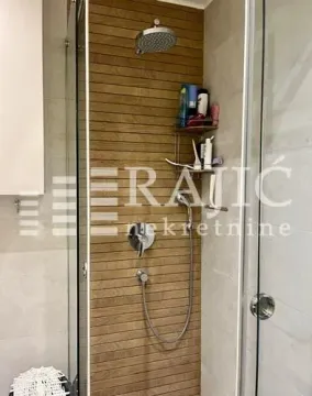 Modern walk-in shower with wooden wall paneling. - image 10
