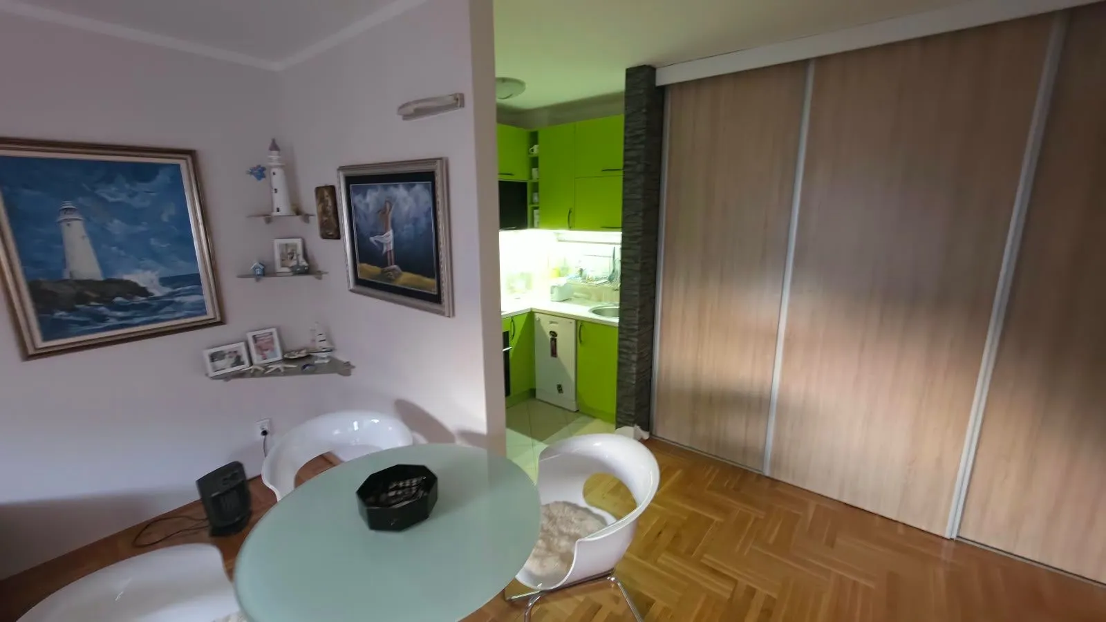 Living room with a dining table and a view of the kitchen.