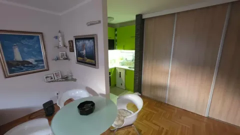 Living room with a dining table and a view of the kitchen. - image 3