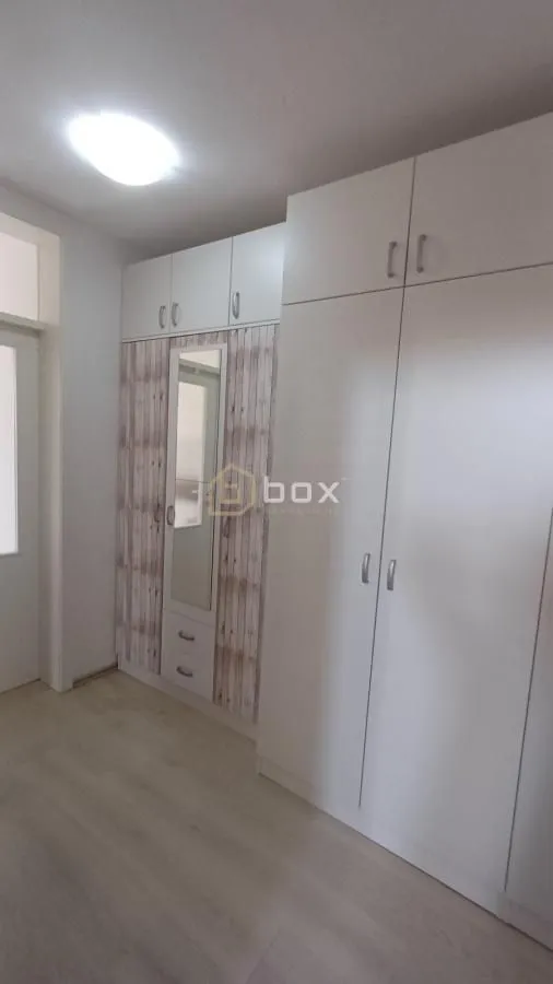 Bedroom with a large built-in wardrobe and a mirror.