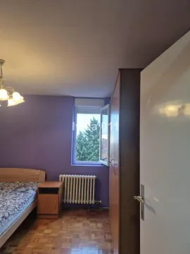 Bedroom with a bed, wardrobe and window. - image 10