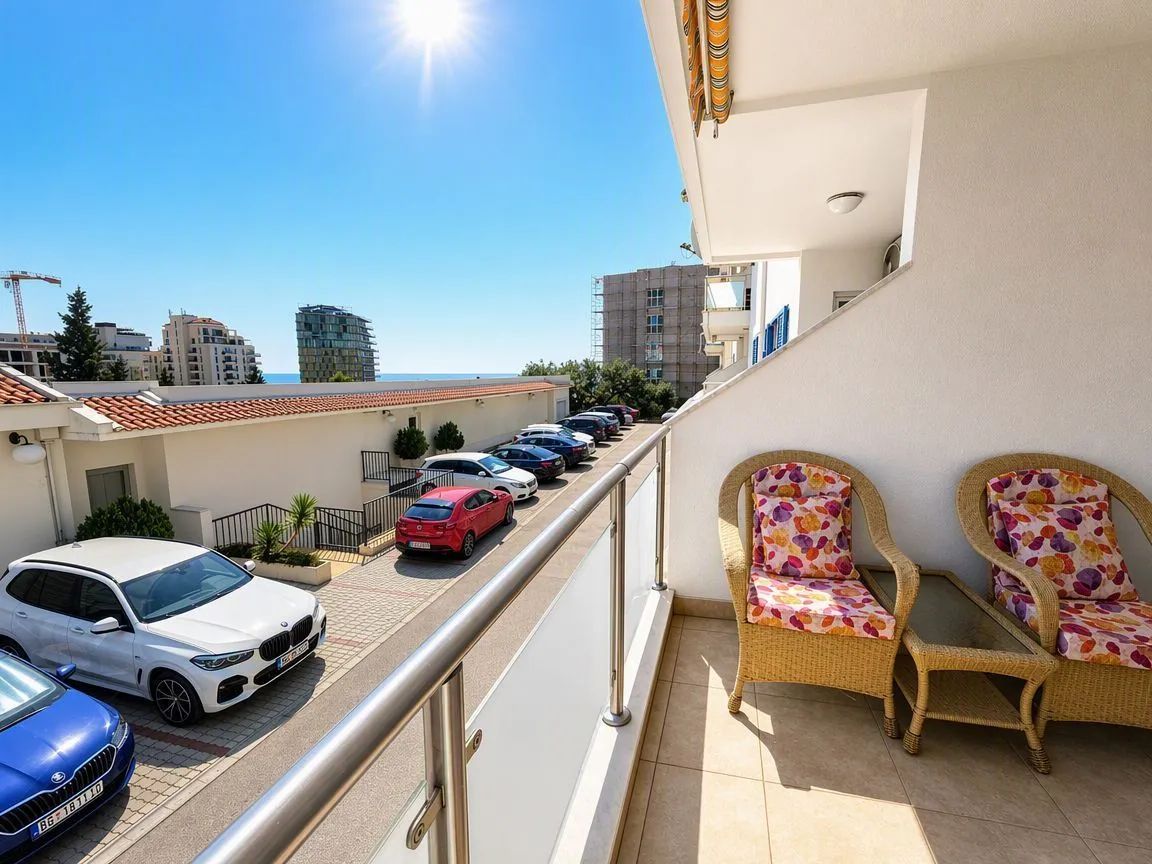 Namješten balkon sa garniturom za sjedenje i pogledom na ulicu i zgrade.