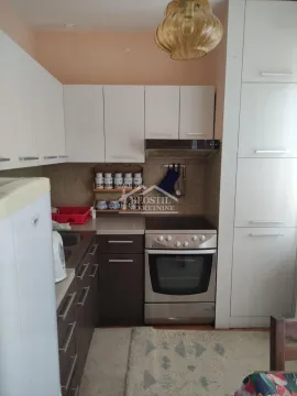 Manja kuhinja sa belim i tamnim elementima i šporetom. - image 5