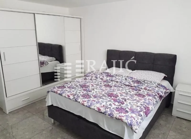 Furnished bedroom with a double bed and a large wardrobe.