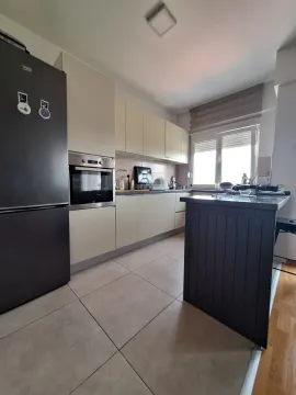 Kuhinja opremljena kuhinjskim elementima, ugradnom rernom i crnim frižiderom. - image 4