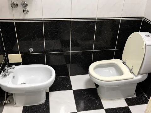Manje kupatilo sa crno-bijelim keramičkim pločicama, šoljom i bideom. - image 8
