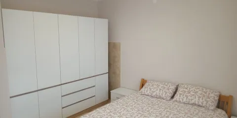 Furnished bedroom with a bed and a large white wardrobe. - image 3