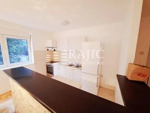 View of a bright kitchen with white cabinets and a breakfast bar. - image 8