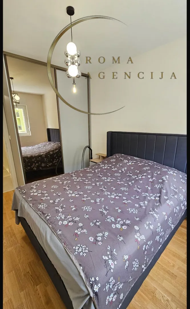 Tidy bedroom with a double bed and a mirrored wardrobe.