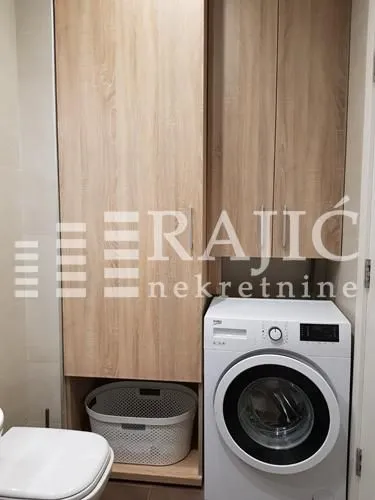 Bathroom with a washing machine, cabinet, and laundry basket.
