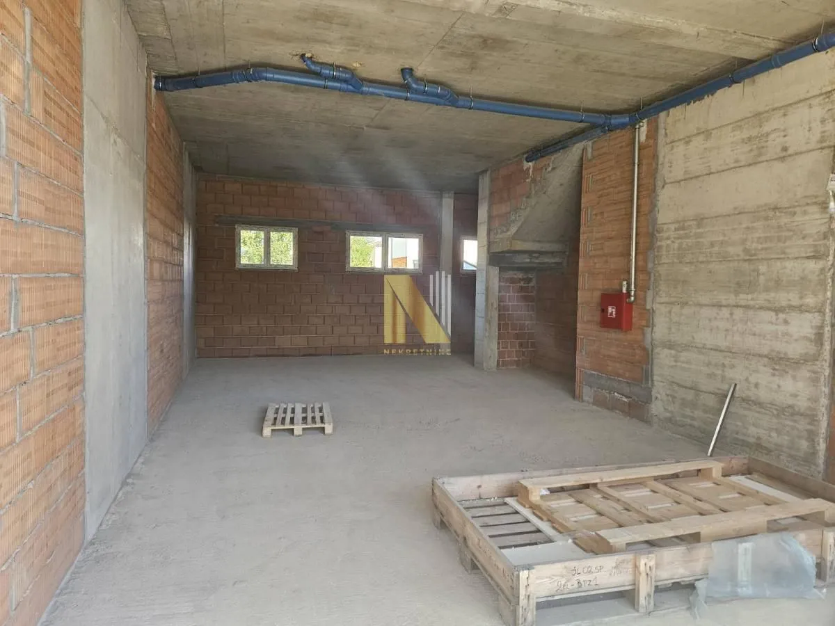 Unfinished interior space in grey phase construction with installations and windows.