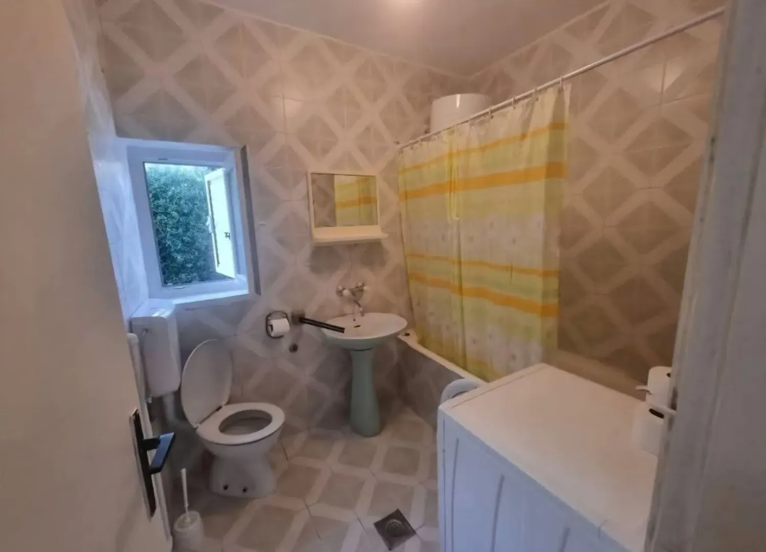 Manje kupatilo sa kadom, umivaonikom i toaletom.