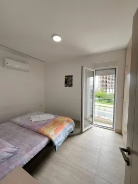 Furnished bedroom with a double bed and access to the terrace. - image 9