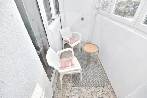 Zastakljeni balkon sa bijelim stolicama, malim stočićem i tepihom. - image 13