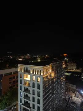 Noćni pogled iz vazduha na osvijetljenu fasadu stambene zgrade. - image 6