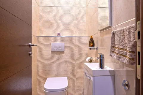 Manje kupatilo sa wc šoljom, umivaonikom i pločicama bež boje. - image 21
