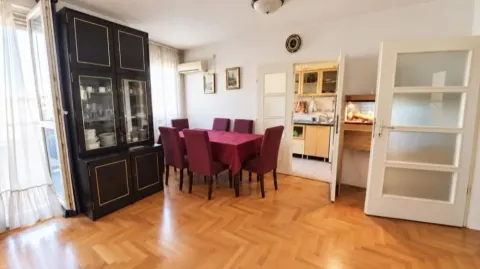 Trpezarija sa drvenim podom, trpezarijskim stolom i stolicama, i pogledom na kuhinju. - image 2