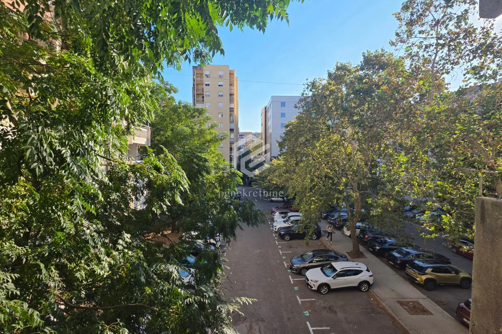 View from the window of the parking lot and surrounding buildings surrounded by greenery.