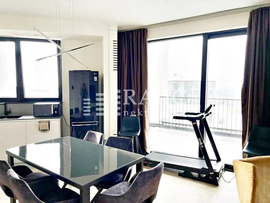 Spacious living room with a dining area, kitchen, and access to the terrace.