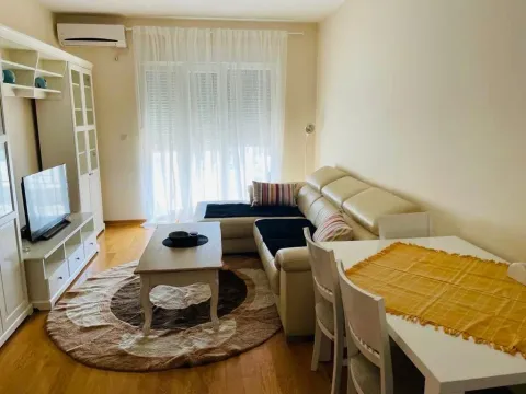 Bright living room featuring a corner sofa, dining table, and TV unit. - image 2